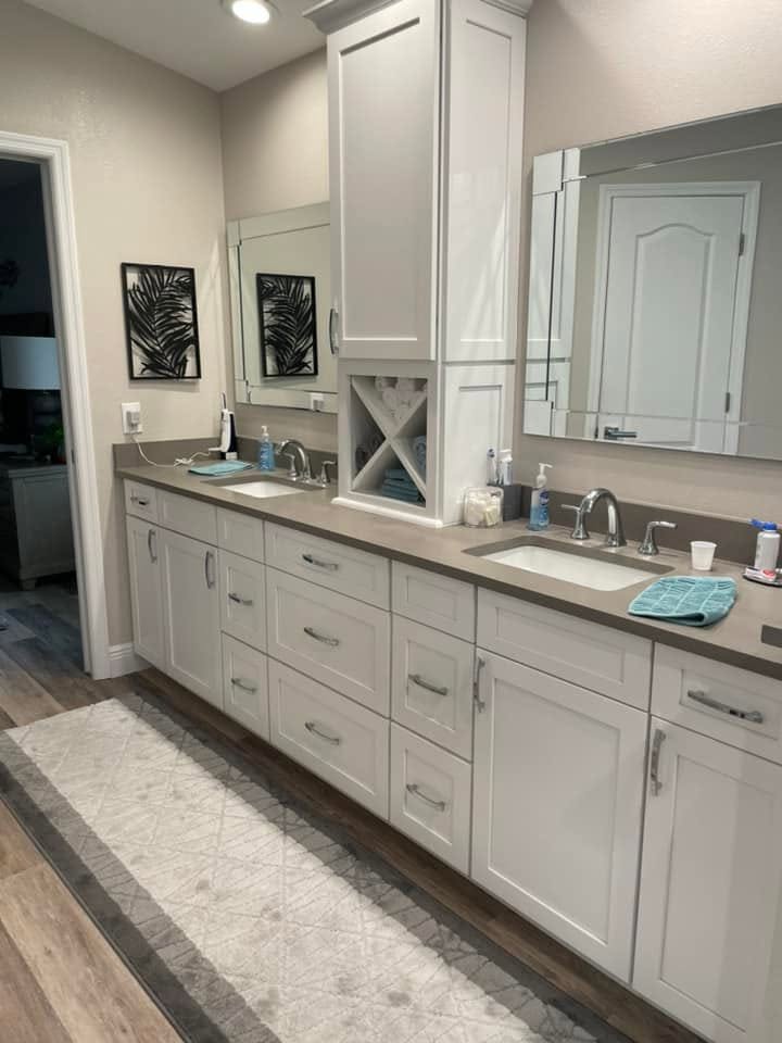 Bright bathroom with freestanding bathtub, pale rectangular floor tiles, and wooden vanity.