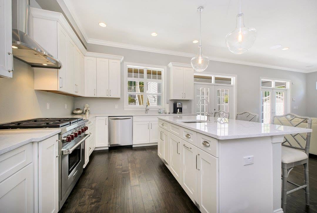White kitchen with dark wood flooring