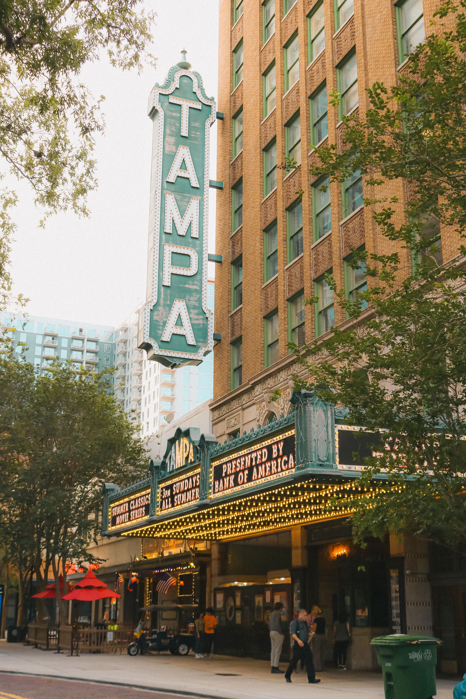 The historic Tampa Theatre features an illuminated marquee and vertical blade sign.
