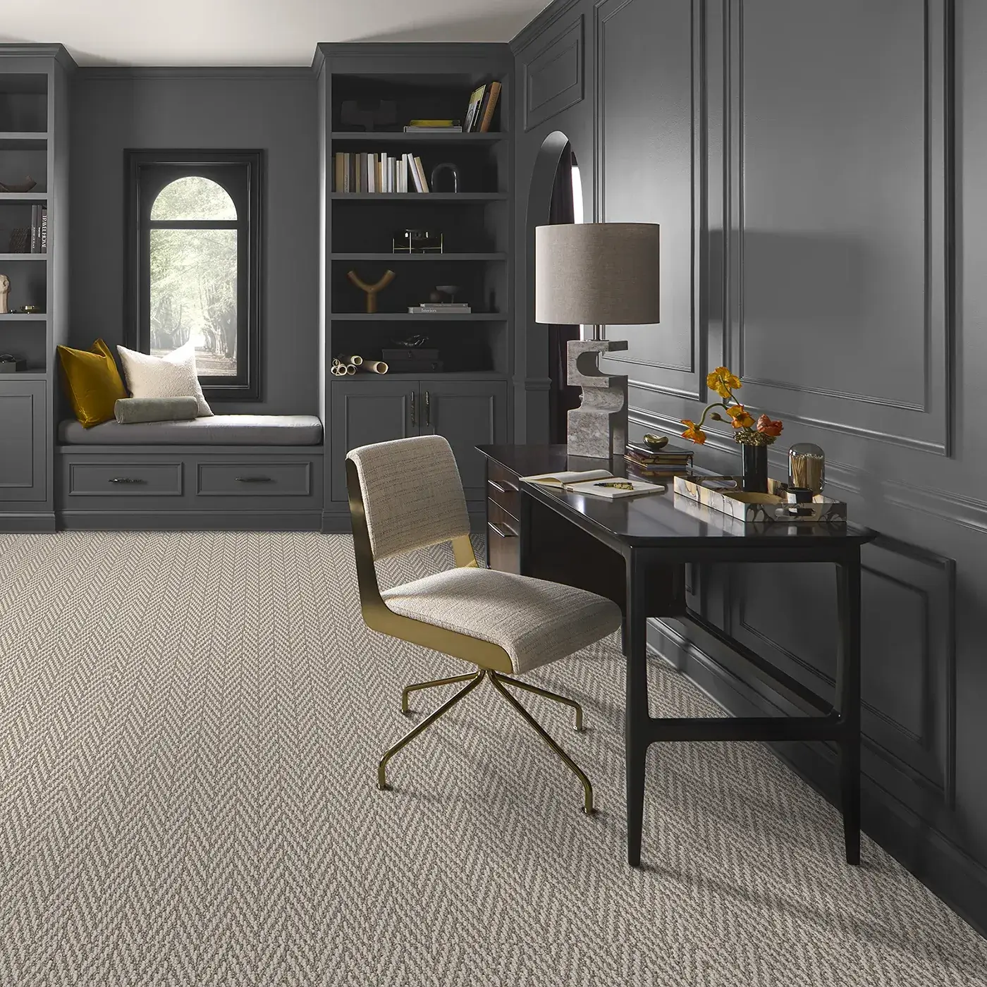 Textured herringbone carpet covers the floor of a dark gray home office.