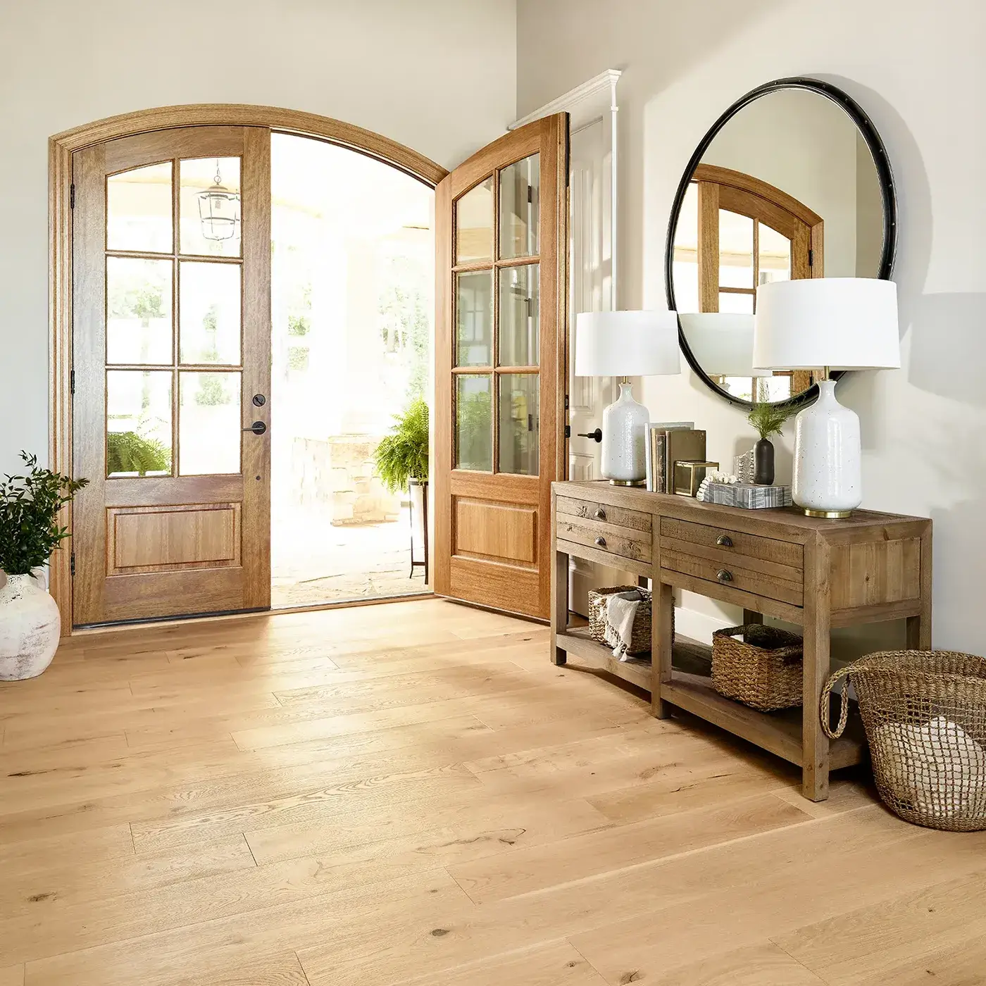 Large foyer with double doors, side table, and hardwood flooring