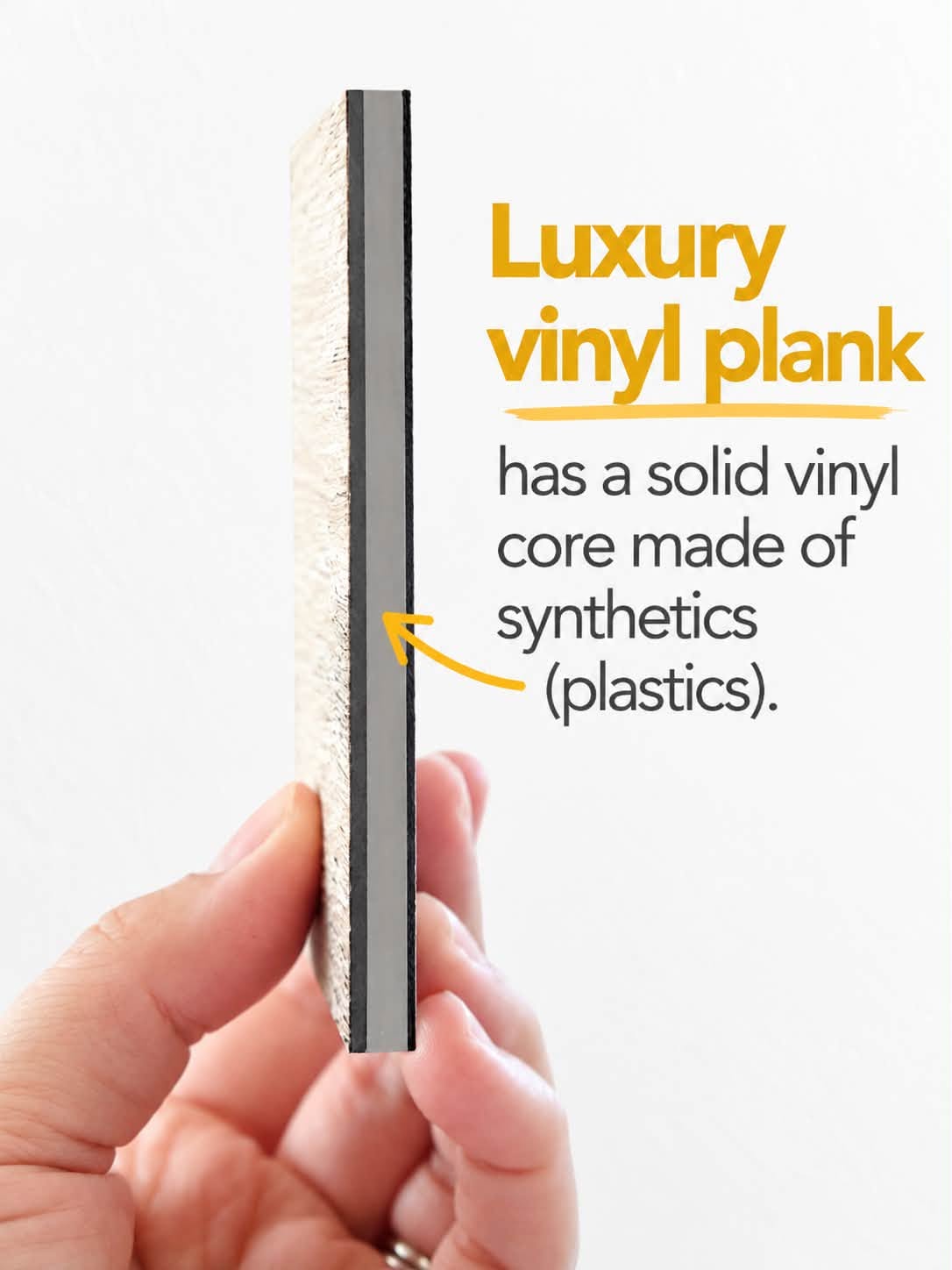 Hand holding a luxury vinyl plank sample displaying its solid vinyl core.